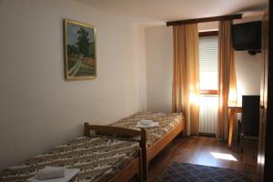 Habitación de hotel con 2 camas y TV en Hostel S, en Novi Sad