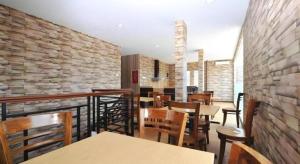 a restaurant with tables and chairs and a brick wall at Amaya Suites Hotel in Yogyakarta