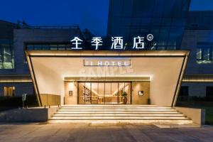 een hotelgebouw met een bord aan de voorzijde bij JI Hotel Shanghai Xuhui Riverside West Bank Center in Shanghai