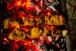 a bunch of food cooking on top of a fire at Sampan Stay Jaldapara in Mādāri Hāt