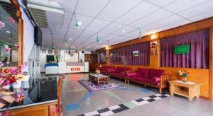 OYO 90929 DJ Hotel في Kampung Damar Laut: غرفة معيشة مع كنب احمر في غرفة