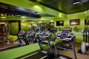 einen Fitnessraum mit einer Reihe von Kardiogeräten in einem Zimmer in der Unterkunft ZiQoo Hotel Apartments Dubai in Dubai