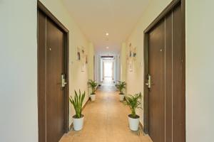 un pasillo con macetas en un pasillo en FabHotel Siddarth Grand, en Vijayawada