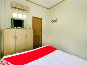 a bedroom with a bed with a red blanket at OYO 1080 Kanyapa Resort Kaeng Krachan in Kaeng Krachan