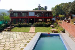 HOTEL GREEN CRYSTAL LINGMALA Mahabaleshwar في ماهاباليشوار: منزل به مسبح امام مبنى +3 صور