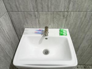 een witte wastafel met tandenborstel en tandpasta erop bij Sky In Homestay Syariah near RSUD Sogaten RedPartner in Madiun