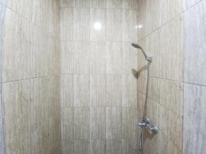 een douche in een badkamer met een tegelwand bij Sky In Homestay Syariah near RSUD Sogaten RedPartner in Madiun