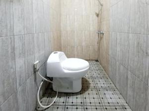 een badkamer met een toilet in een betegelde kamer bij Sky In Homestay Syariah near RSUD Sogaten RedPartner in Madiun