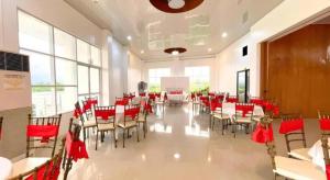 a banquet hall with red chairs and tables and windows at Pilot Hotel in Amandiego