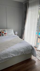 une chambre avec un lit et une grande fenêtre dans l'établissement Home stay Ev Coffeehouse, à Ban Map Khao Wan