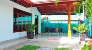 a patio of a house with chairs and tables at Hotel camorich in Debarawewa