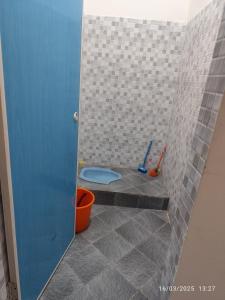 e bagno con servizi igienici e pavimento piastrellato. di Berastagi a Berastagi Altre 4 foto