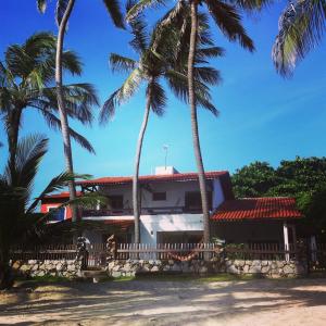 a house with palm trees in front of it at ITACUPA - Healthy VEGAN & FOIL Center in Cumbuco