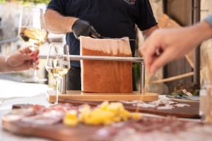 a man is preparing food with two glasses of wine at Holiday Home Pr'Lukčevih with 4 Bedrooms & Sauna in Kanal