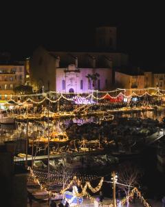 L'Olivier - Centre Ciotat à pied في لاسيوتا: ميناء مضاء في الليل بأضواء عيد الميلاد