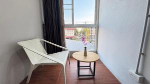 una camera con una sedia, un tavolo e una finestra di Collection O Mahidol Road a Chiang Mai