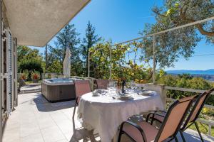 a table and chairs on a patio with a hot tub at Apartment Paris with jacuzzi and sea view in Šmrika