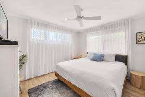 BuddinaにあるFamily Home Near Cafes and Surf Beachesの白いベッドルーム(青い枕の大型ベッド付)