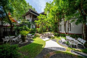 a garden with chairs and tables in front of a house at Kirikayan Boutique Resort - SHA Extra Plus in Chaweng