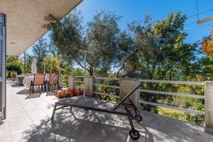 a patio with a fence and a table and chairs at Apartment Paris with jacuzzi and sea view in Šmrika