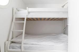 a bedroom with two bunk beds with white sheets at Tott vacation homes in Åre