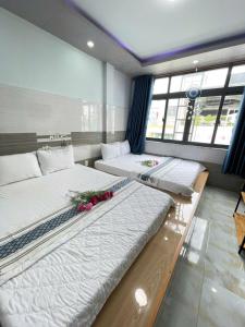 Ong 5 Homestay Can Tho في كان ثو: سريرين في غرفة عليها زهور