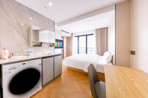 a kitchen and a bedroom with a bed and a table at Prime Pazhou Aparthotel - Pazhou Station Line 8 and 11 - Steps away from Canton Exhibition Center in Guangzhou +35 photos