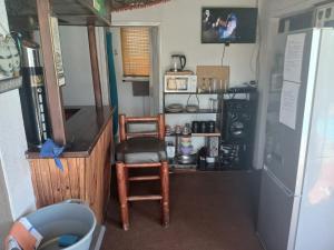 een keuken met een koelkast, een tafel en een stoel bij Braai and chill getaway in Goodwood