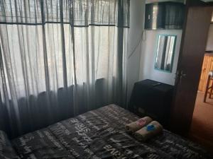 een slaapkamer met een bed en een raam met gordijnen bij Braai and chill getaway in Goodwood