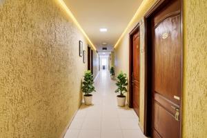 a corridor with potted plants in a hallway at FabHotel Tap Inn in Bengaluru