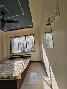 Habitación con 1 cama y 2 ventanas en Swami Greens - Private Peaceful Staycation, en Jāmb