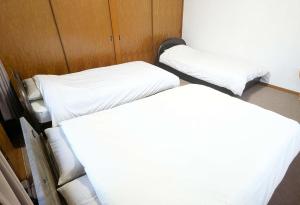 Nomuroにあるコテージ自給自足 伊根の白いシーツが敷かれた部屋にベッドが2つ