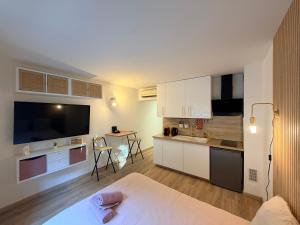 una cocina con armarios blancos y una mesa en una habitación en Le Clos d'AIX studio 1, en Aix-en-Provence