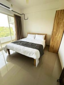 una cama grande en una habitación con ventana en Dodamarg Heights, en Dodamarg