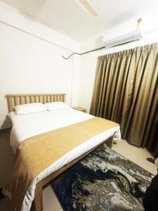 Un dormitorio con una cama y una ventana con cortinas. en Dodamarg Heights, en Dodamarg 2 fotos más