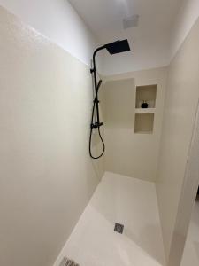baño con ducha con una luz en la pared en Le Clos d'AIX studio 1, en Aix-en-Provence