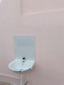 un lavandino bianco su una parete bianca di Adb's Kuzhlam Rooms a Tiruchchirāppalli