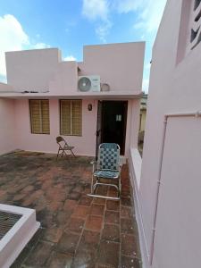 una casa con due sedie su un patio di Adb's Kuzhlam Rooms a Tiruchchirāppalli