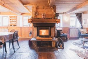 a fireplace in a room with a table and chairs at La Ferme a Mamy - Snowytrees in Morzine