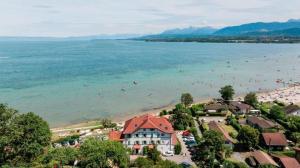 La petite maison de la plage I Excenevex في إكسينيفيكس: اطلالة على شاطئ فيه ناس في الماء