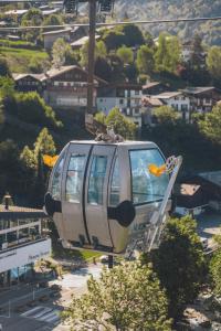 a cable car is flying over a city at La Ferme a Mamy - Snowytrees in Morzine +46 photos