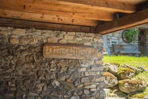 a sign on the side of a stone wall at La Ferme a Mamy - Snowytrees in Morzine