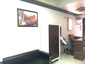 a room with a couch and a painting on the wall at Sakshi Seva Sadan Vrindavan Homestay & Restaurant in Vrindāvan