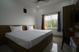 Postel nebo postele na pokoji v ubytování Staymax Parassinikadavu