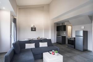 a living room with a blue couch and a kitchen at Panorama Sunvilles Apartment 9 in Thessaloniki +9 photos