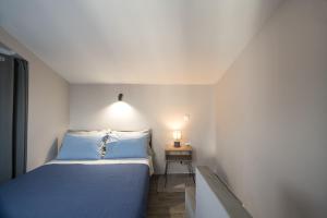 a small bedroom with a blue bed and a side table at Panorama Sunvilles Apartment 9 in Thessaloniki