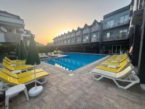 een hotel met een zwembad met gele ligstoelen bij Grand Nar Hotel ADULT ONLY - All Inclusive in Kemer