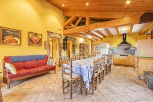 a living room with a table and a red couch at Cal Viudet Vell in Caserras