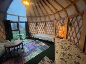 a room with two beds and a table in a yurt at Unique Mongolian Yurt with Two small Guest houses by lake rent out as One in Hjo