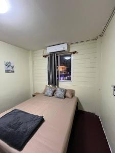 a large bed in a room with a window at Happy Hope Khao San in Bangkok